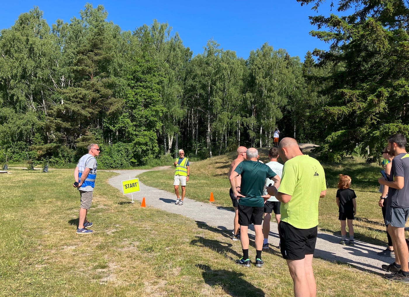 Participants in the clearing at the start, with the forest ahead.