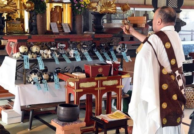 Kofuku-ji temple chief priest Bungen Oi (R) offers a prayer during the funeral for 19 Sony's pet robot AIBOs, in Isumi, Japan's Chiba prefecture ©Toshifumi Kitamura (AFP) [Courtesy Daily Mail]