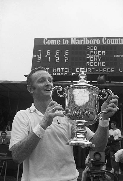 Forest Hills, NY: Rod Laver of Australia flashes a big grin as he holds the winner's trophy at the US Open Tennis Championships Sept. 8th. Scoreboard...