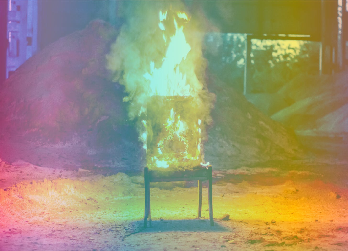 A rainbow-filtered image of a chair in flames
