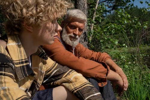 Free Grandfather and Grandson Sitting in a Forest Stock Photo
