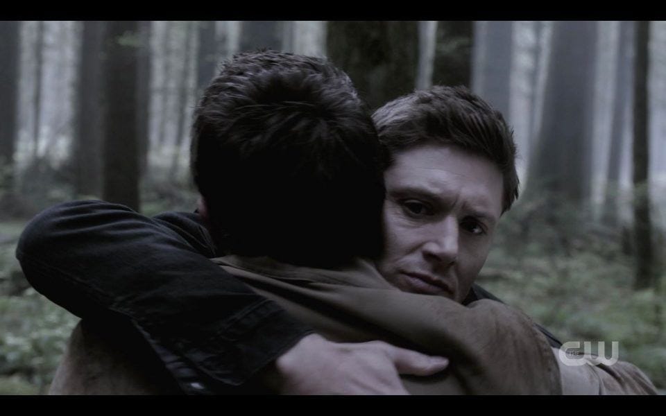 Dean Winchester huggin Castiel tight in woods SPN