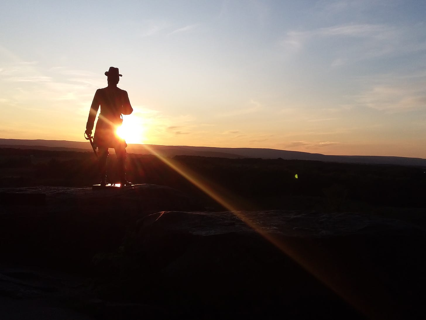 General Warren monument on Little Round Top with sun setting.