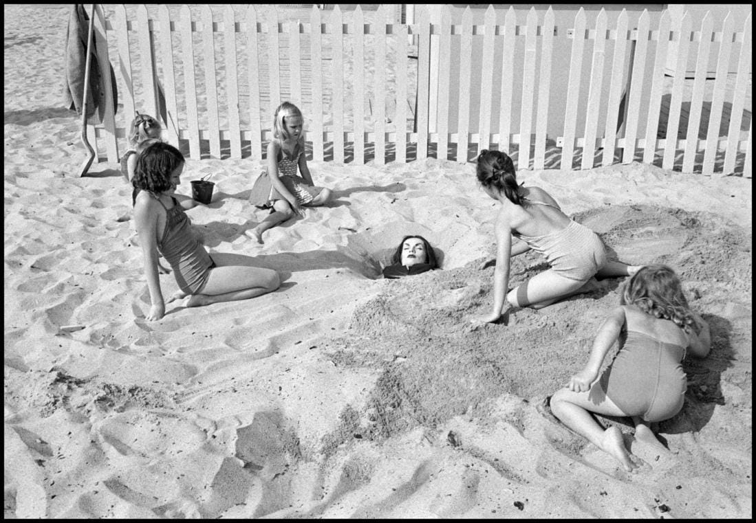 A group of women playing in the sand

Description automatically generated