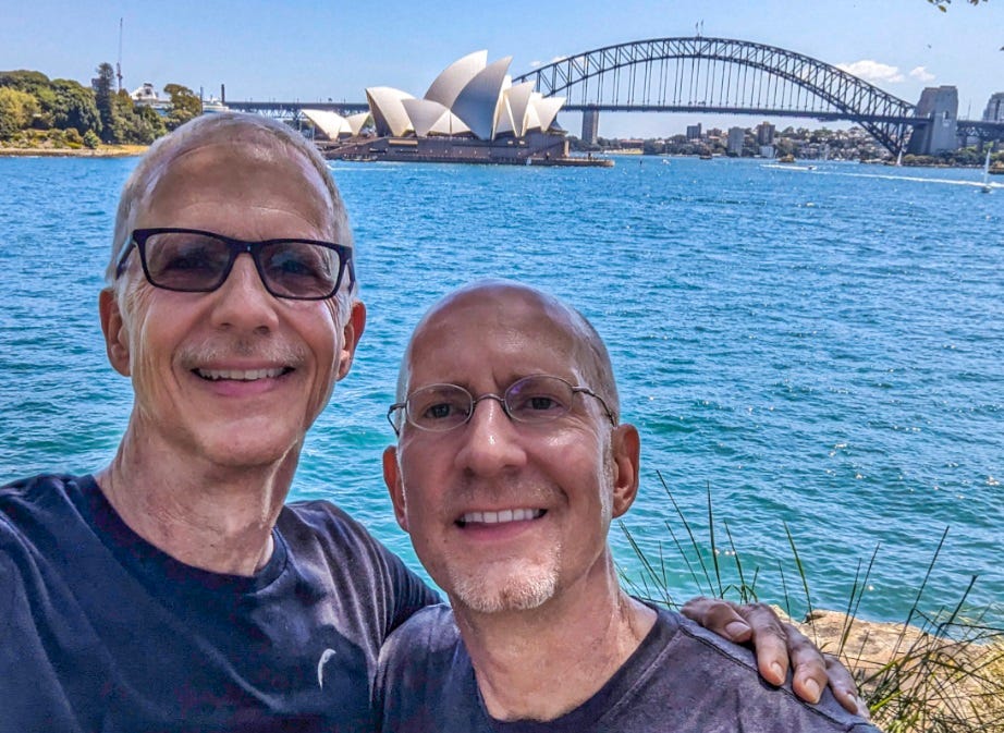 Brent and Michael standing in front of theSydney and the Opera House and Harbour Bridge.
