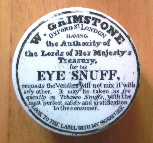 A circular ceramic pot lid with black writing giving directions for the use of Grimstone's Eye Snuff.