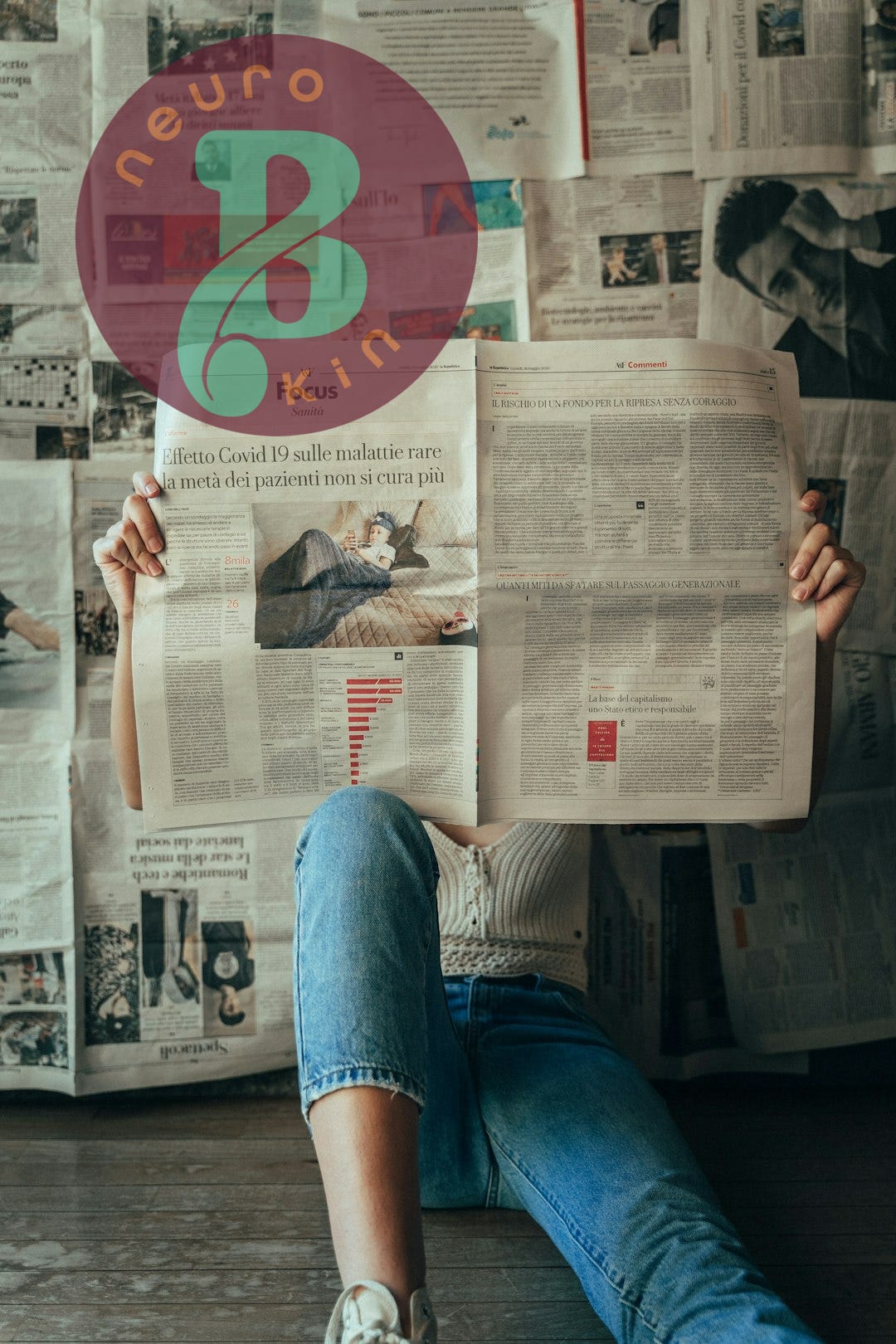 person in blue denim jeans holding white magazine