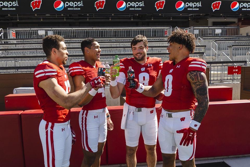 Braelon Allen, C.J. Williams, Tanner Mordecia and Chimere Dike in Wisconsin uniforms holding Pepsi products