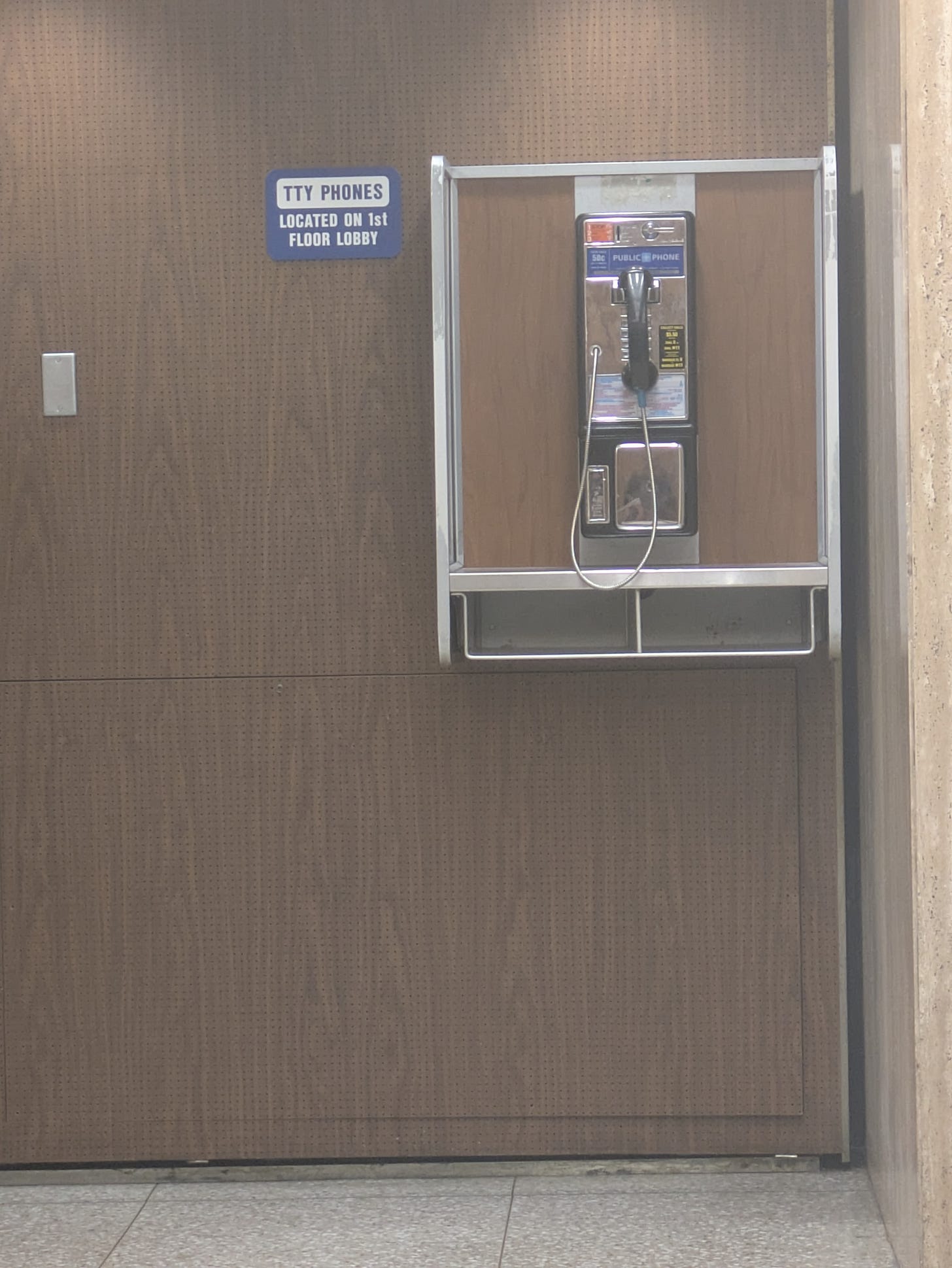 A payphone inside a dreary courthouse