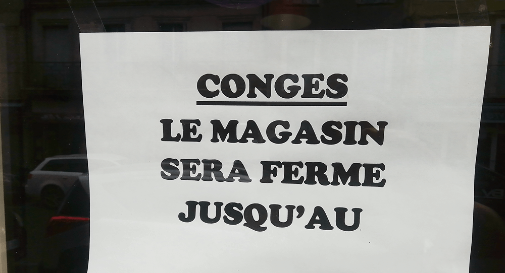 'Holidays. Closed' sign in shop in France. (c) Chris Aspinall, 2023