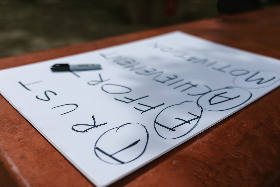 Free A paper with motivational words and markings placed outdoors on a table. Stock Photo