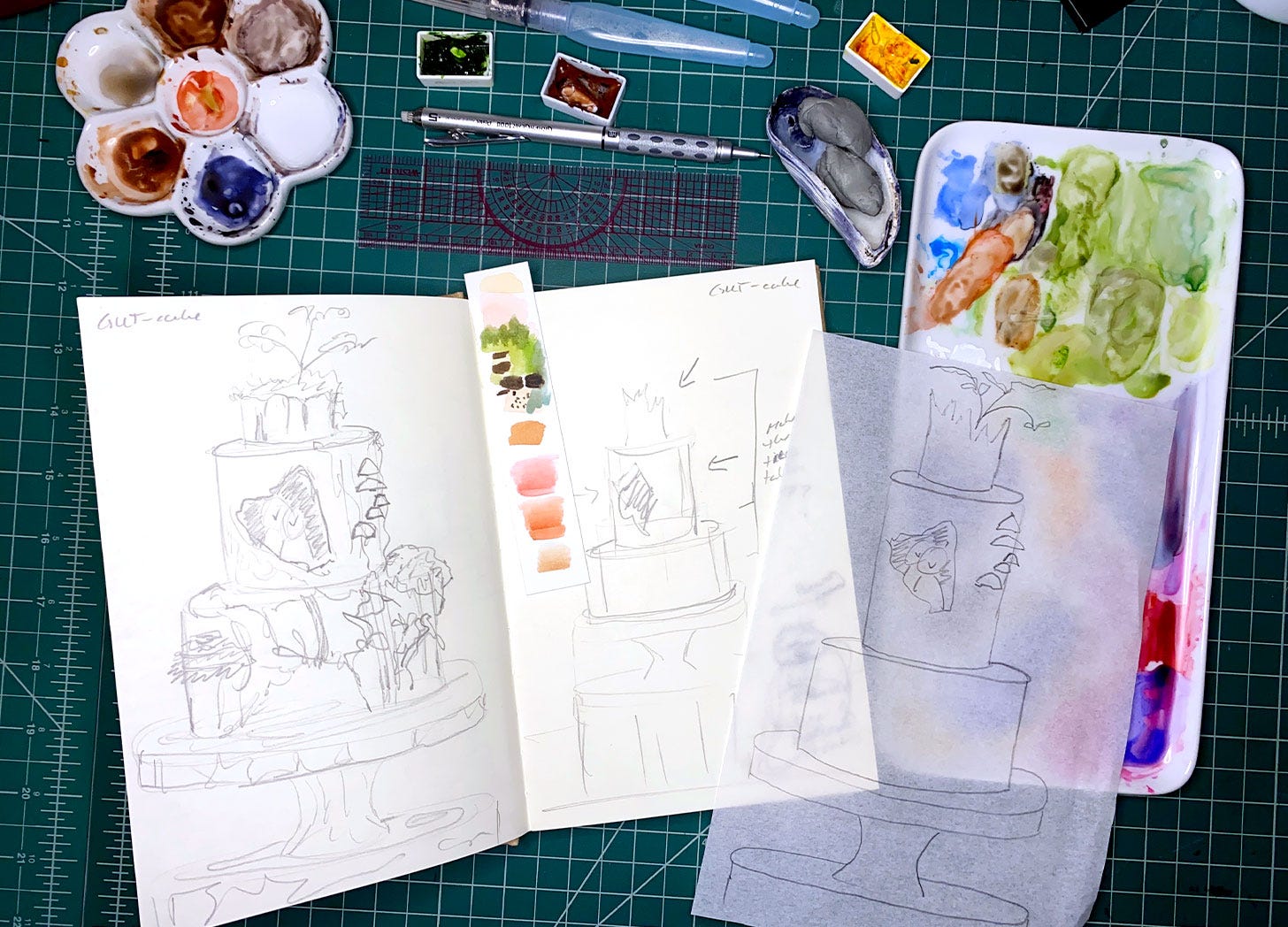 sketches paint brushes and paint on desk 