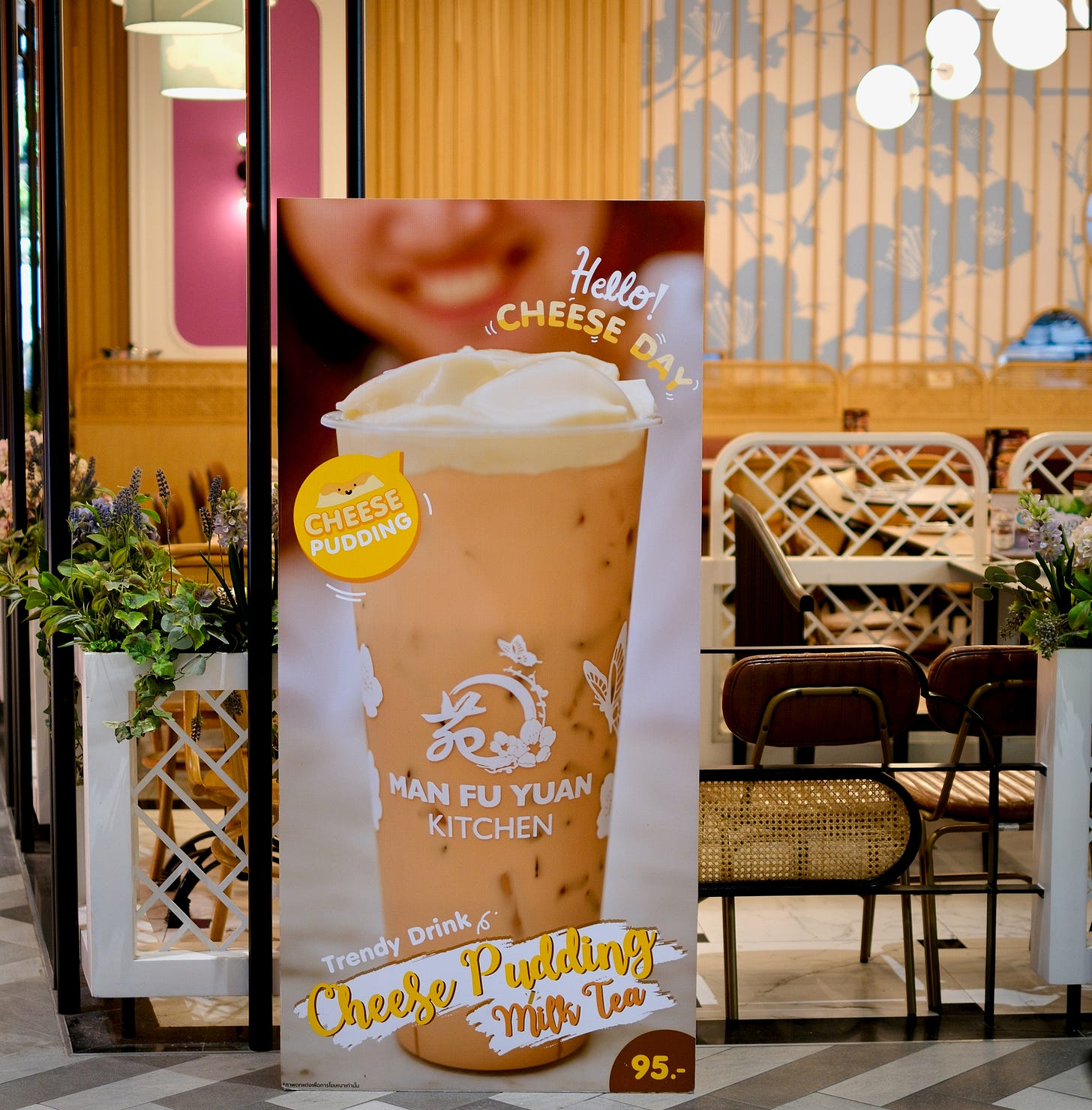 sign in front of restaurant with image of Cheese Pudding Milk Tea