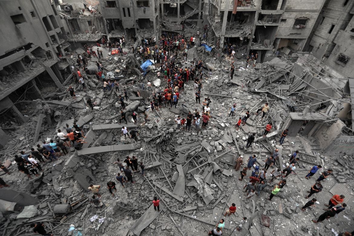 Palestinians inspect the damage of destroyed buildings following Israeli airstrikes on Gaza City