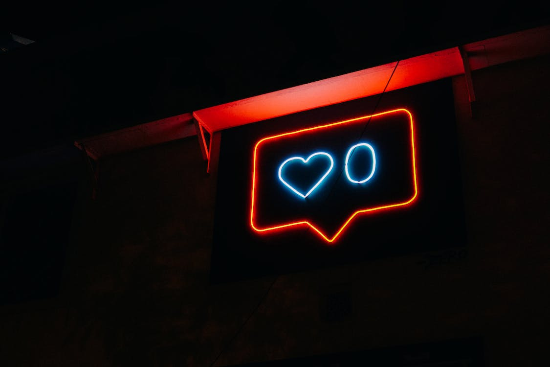 Blue heart and zero within red speech bubble neon sign stock photo.