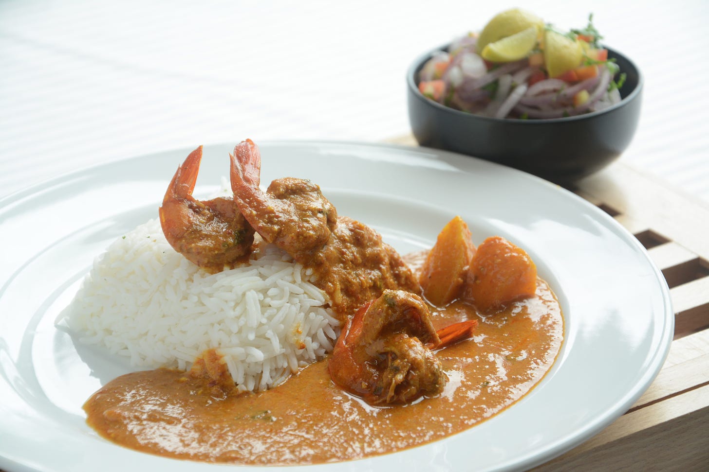 Curry served on a white plate with rice.