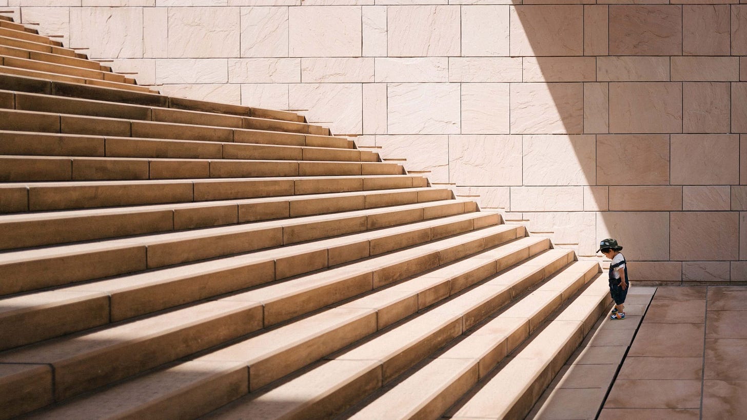 kid at the bottom of a large stairs