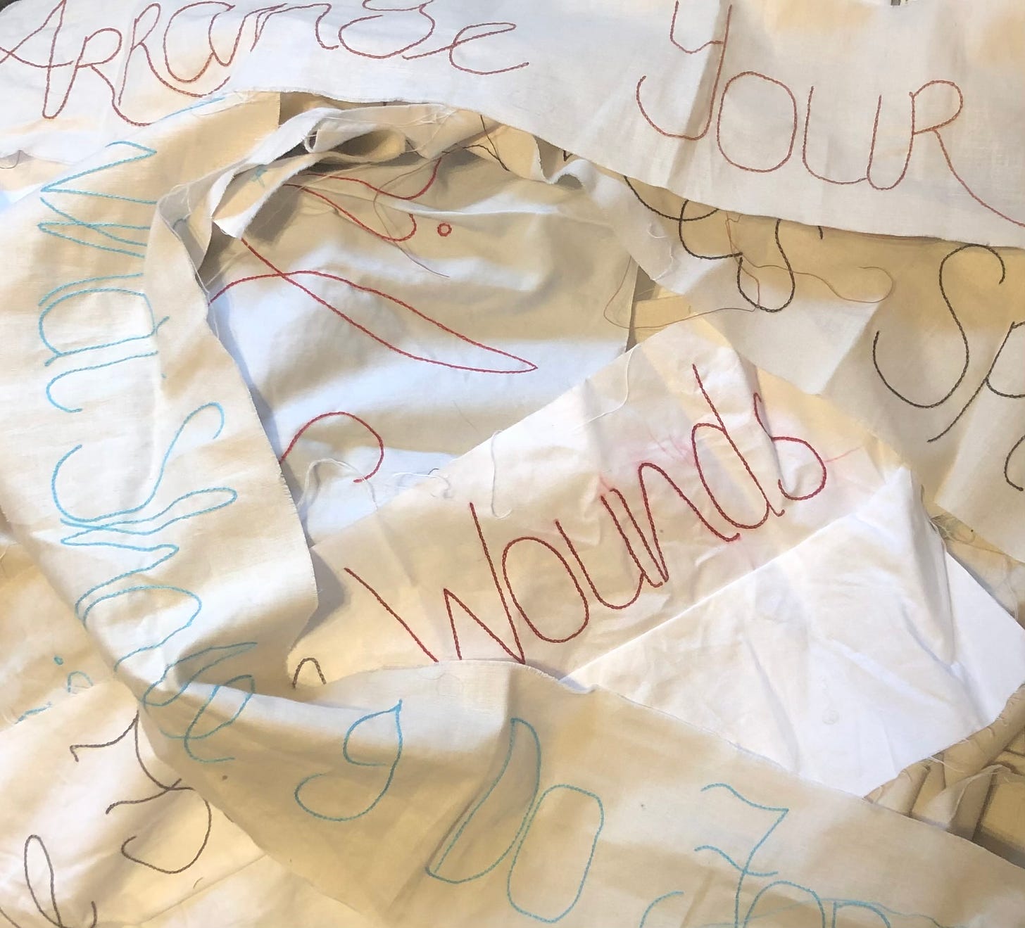 Strips of fabric stitched with various words in different colours