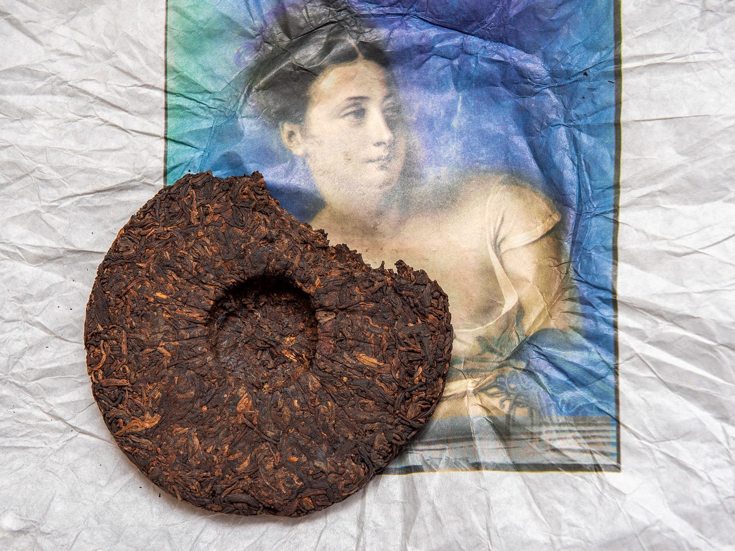 ID: Smokeshou ripe puer cake on top of its wrapper