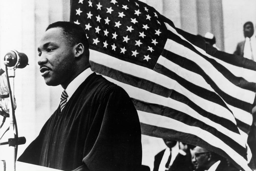 Martin Luther King Jr speaking in front of American flag