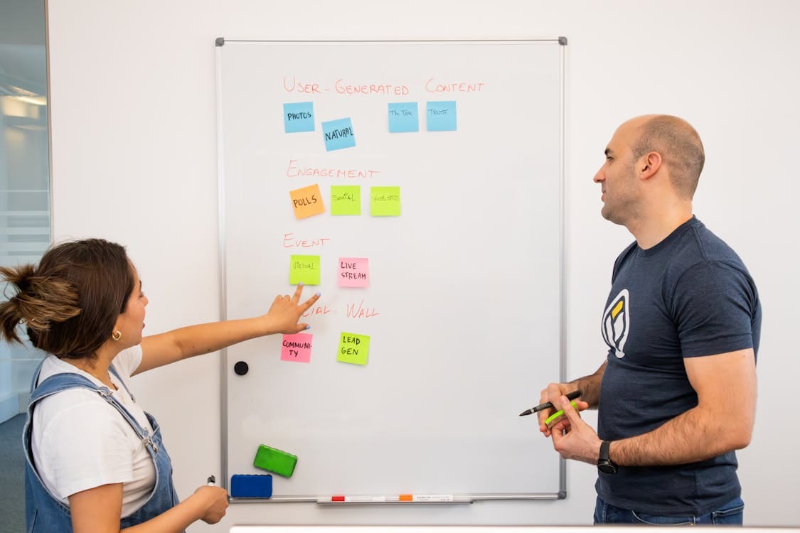 Colleagues Standing by Whiteboard · Free Stock Photo