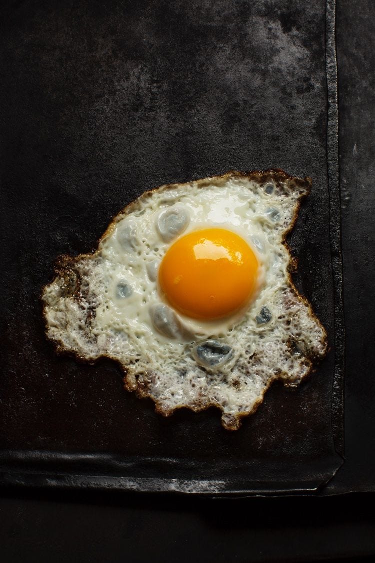 a fried egg against a black background