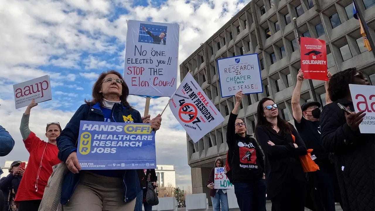 Federal workers, union members, and healthcare advocates protest outside the U.S. Department of Health and Human Services, holding signs that read “Hands off our healthcare research jobs,” “Stop the Elon Coup,” and “Research is cheaper than disease!!” The demonstration followed mass layoffs under the Department of Government Efficiency (DOGE), a Musk-backed initiative targeting public sector infrastructure. Federal workers, union members, and healthcare advocates protest outside the U.S. Department of Health and Human Services, holding signs that read “Hands off our healthcare research jobs,” “Stop the Elon Coup,” and “Research is cheaper than disease!!” The demonstration followed mass layoffs under the Department of Government Efficiency (DOGE), a Musk-backed initiative targeting public sector infrastructure.