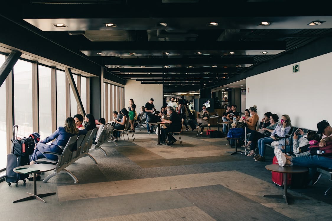 Free People Sitting Inside the Airport Terminal Stock Photo