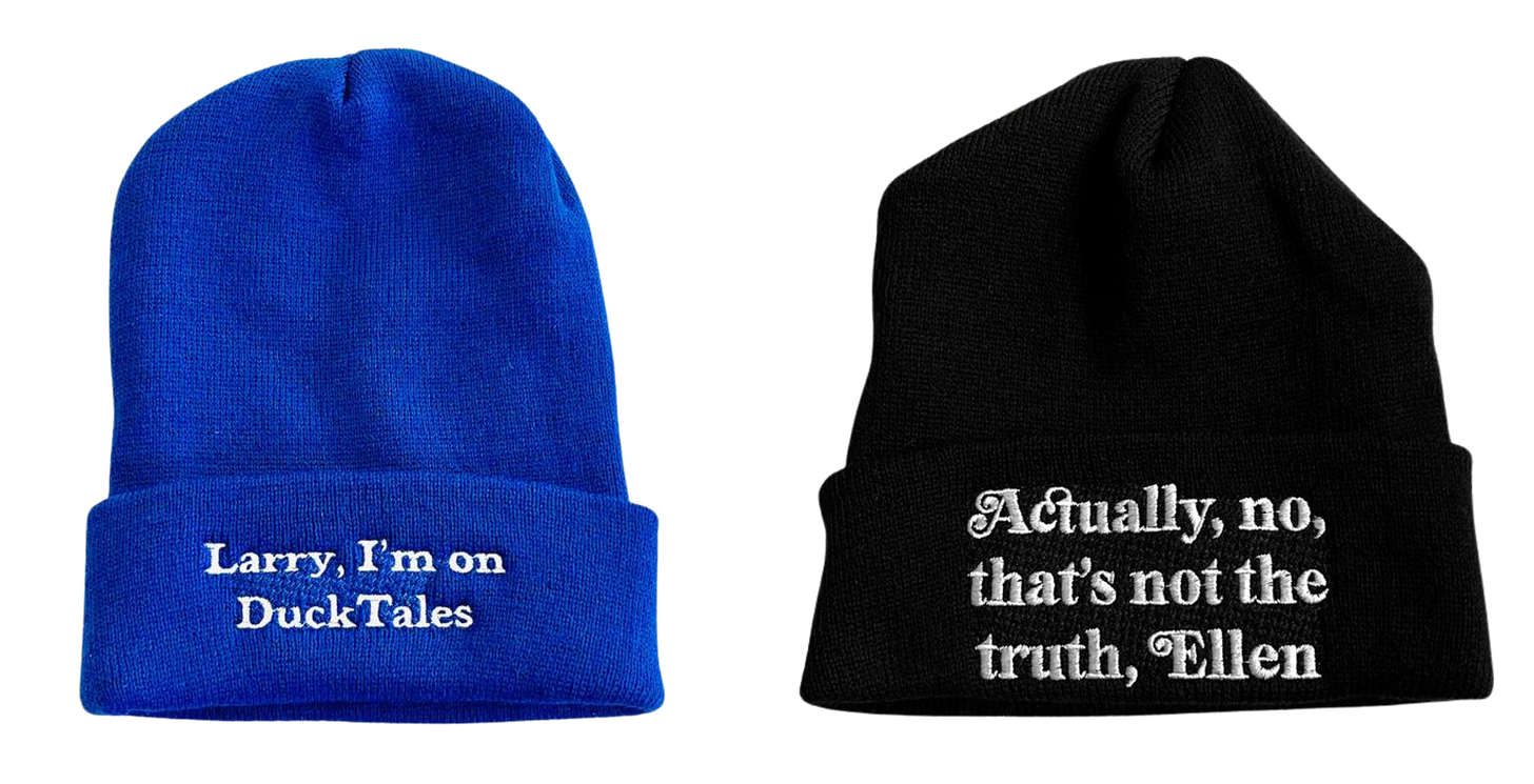 Left, a bright blue beanie with white writing on it that reads, "Larry, I'm on DuckTales." Right, a black beanie with white writing on it that reads, "Actually, no, that's not the truth, Ellen."