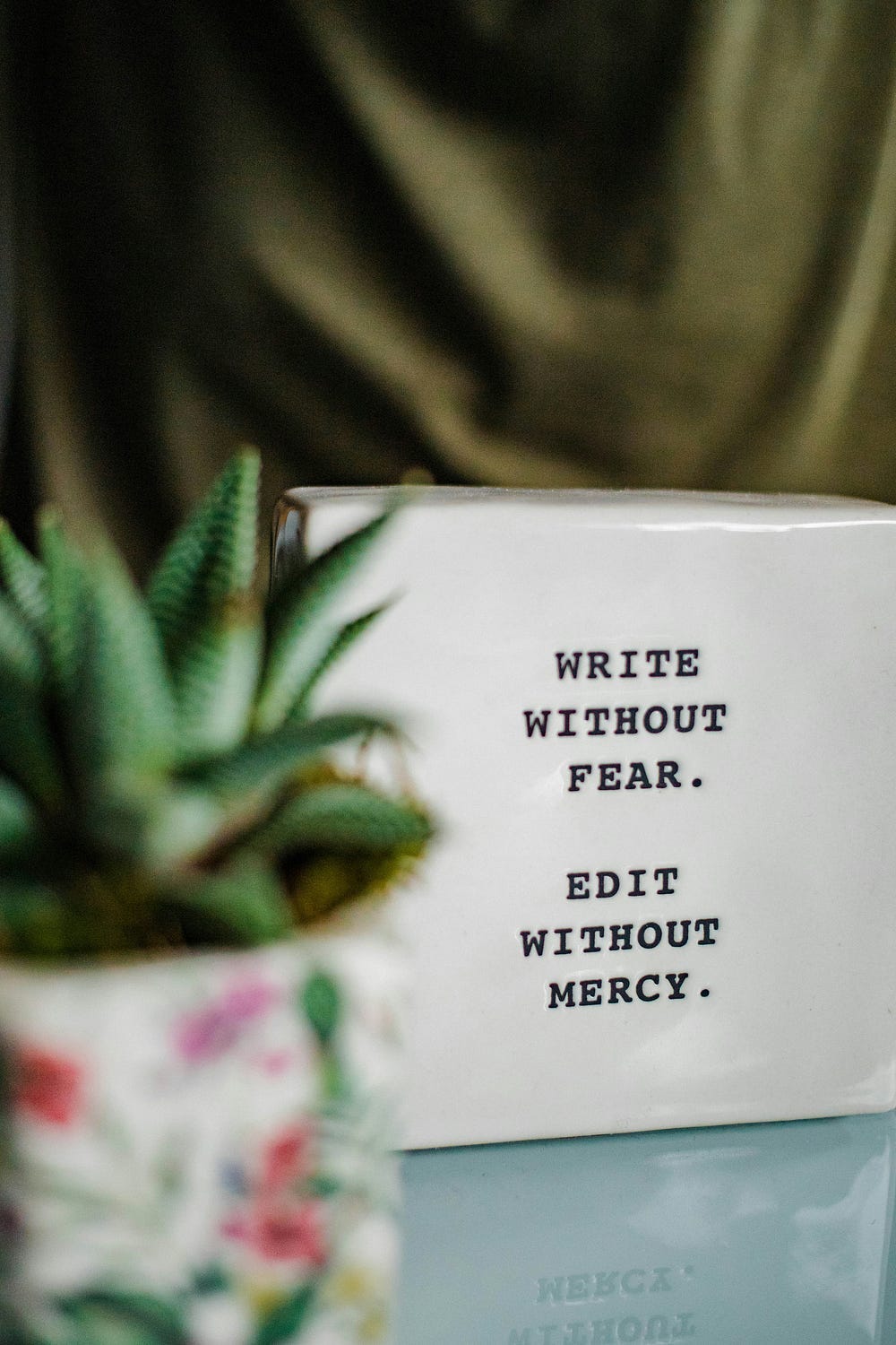 Sign that says, “Write without Fear and Edit without Mercy”.