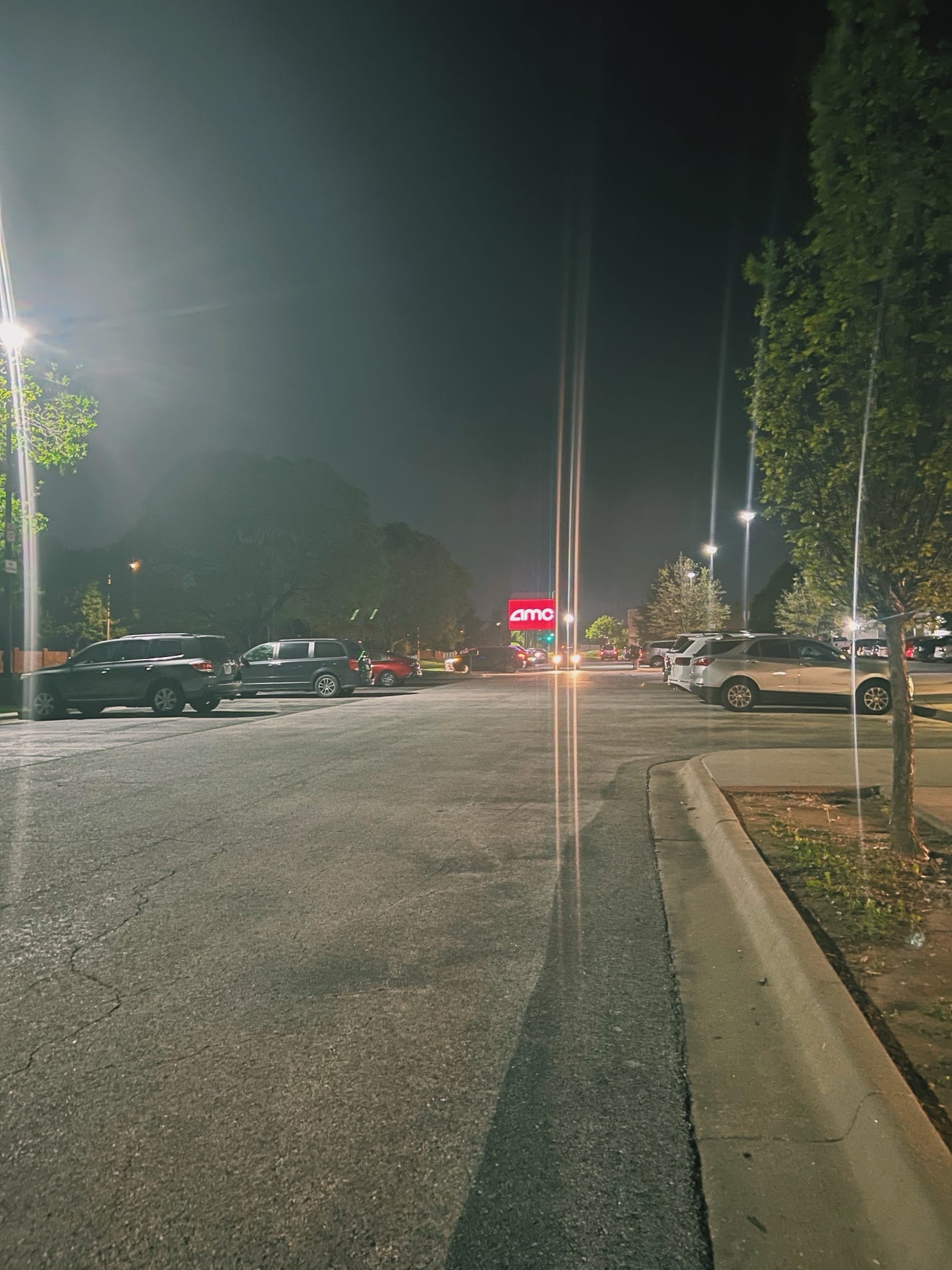 A street at night with cars and trees

AI-generated content may be incorrect.