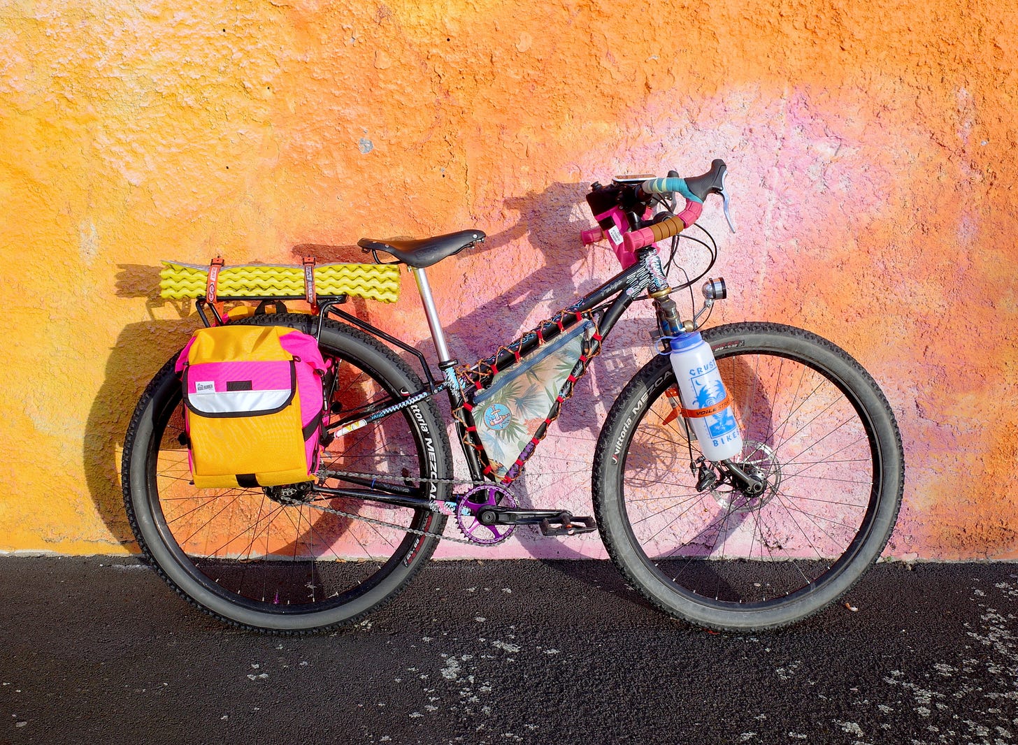 Robbie's bike is a mismash of parts, with bright colorful bags attached
