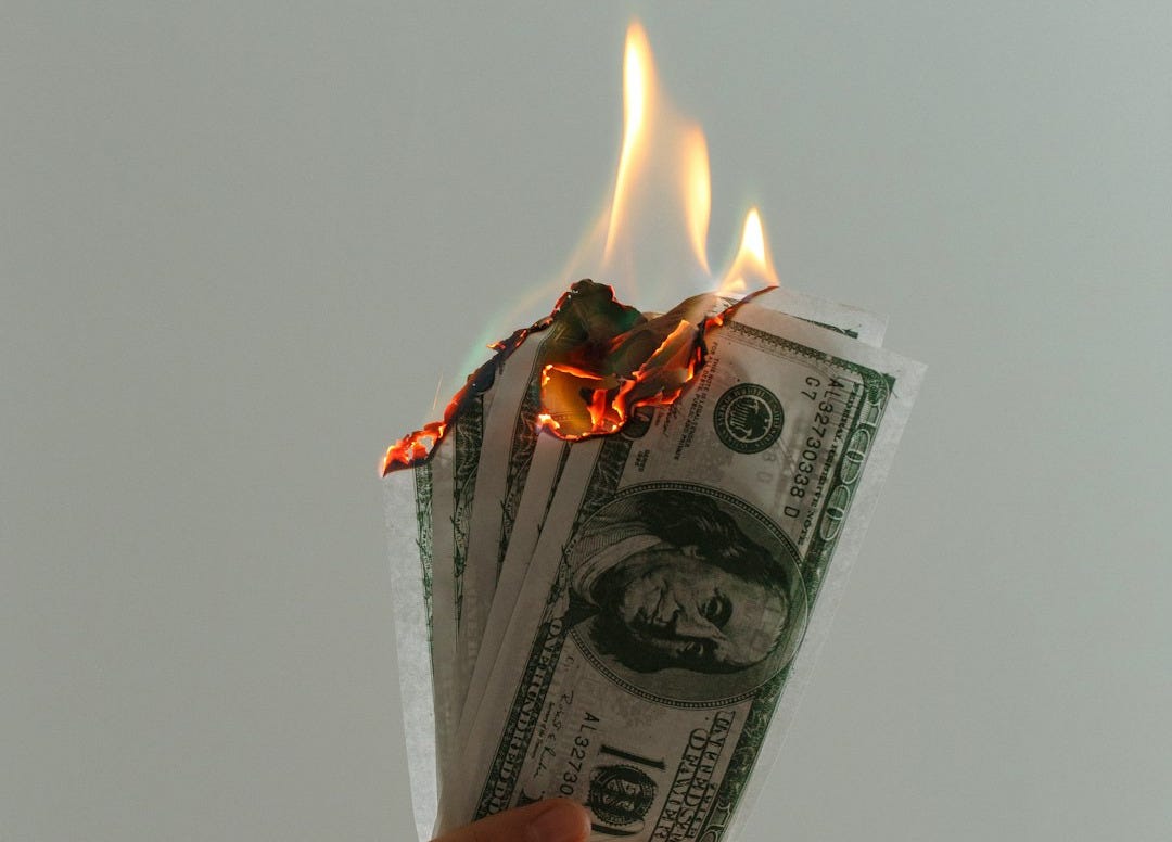 time lapse photography of several burning US dollar banknotes