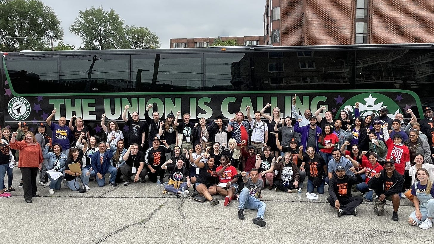 A group of Starbucks workers poses in front of the union's bus during a nationwide tour in July