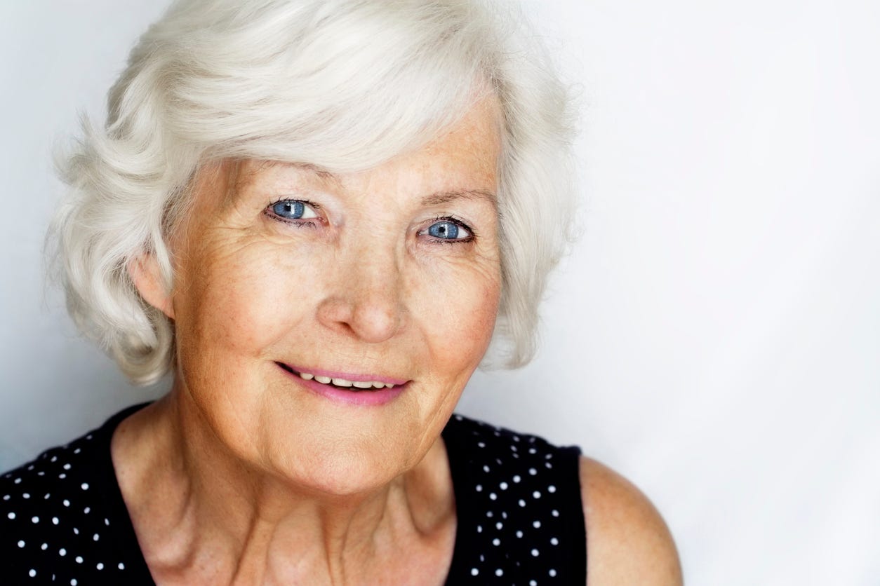 Smiling white, older woman with blue eyes and white hair. 