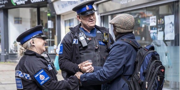 Two Police Community Support Officers in conversation with a member of the public