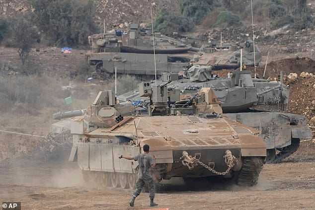 Israeli armored personnel carriers (APC) and tanks maneuver in a staging area in northern Israel near the Israel-Lebanon border, Tuesday, Oct. 1, 2024