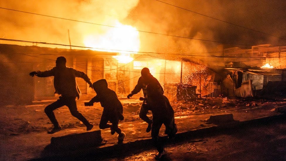 People are running away from a blast fire in the night.