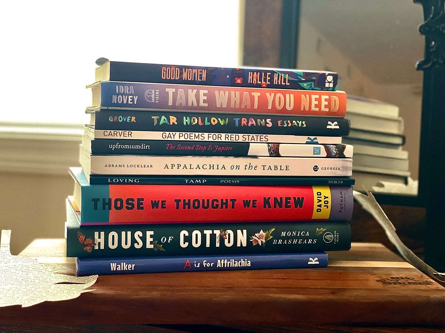 a photo of a stack of Appalachian books sitting on a wooden shelf.