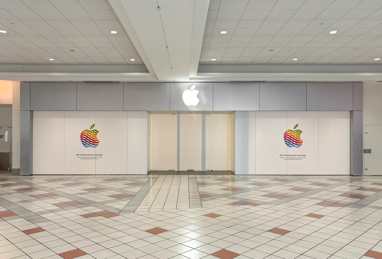 The exterior of Apple's old location at South Shore Plaza. White vinyl covers the windows, and the heritage logo informs customers that a new store has opened close by. 