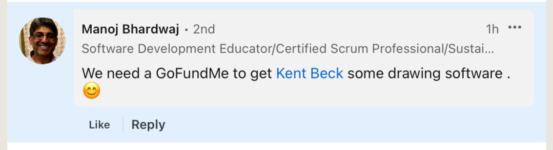 This image shows a LinkedIn post from Manoj Bhardwaj, whose profile indicates he is a "Software Development Educator/Certified Scrum Professional/Sustai..." (title appears to be cut off). The post was made 1 hour ago and reads: "We need a GoFundMe to get Kent Beck some drawing software." followed by a smiling emoji with rosy cheeks. The post includes "Like" and "Reply" buttons at the bottom.