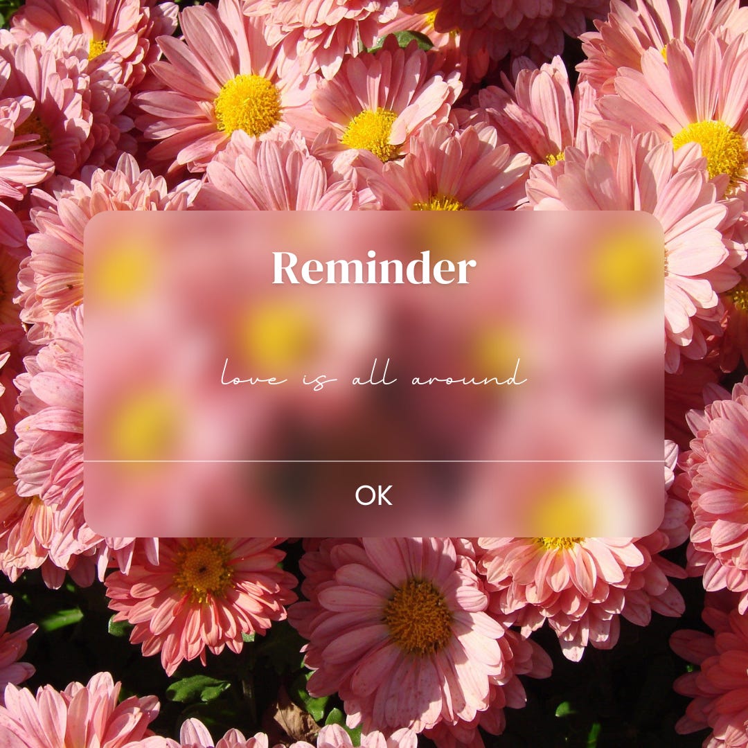 the background is a bunch of pink daisies with yellow centers. a pop-up phone reminder reads: Reminder love is all around (in cursive) [OK button]