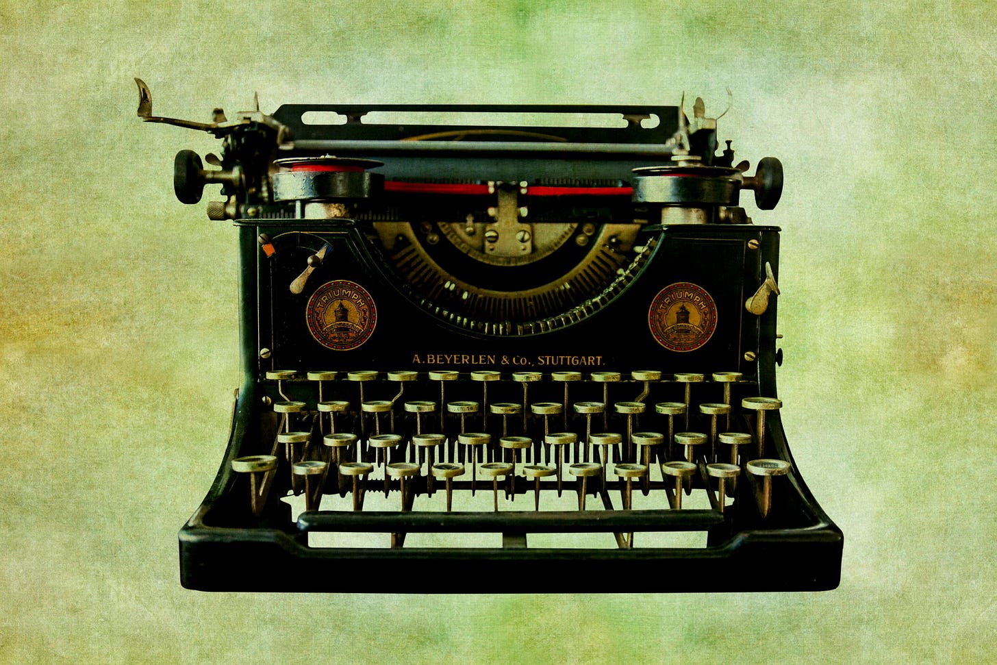 Vintage black typewriter on a green parchment background