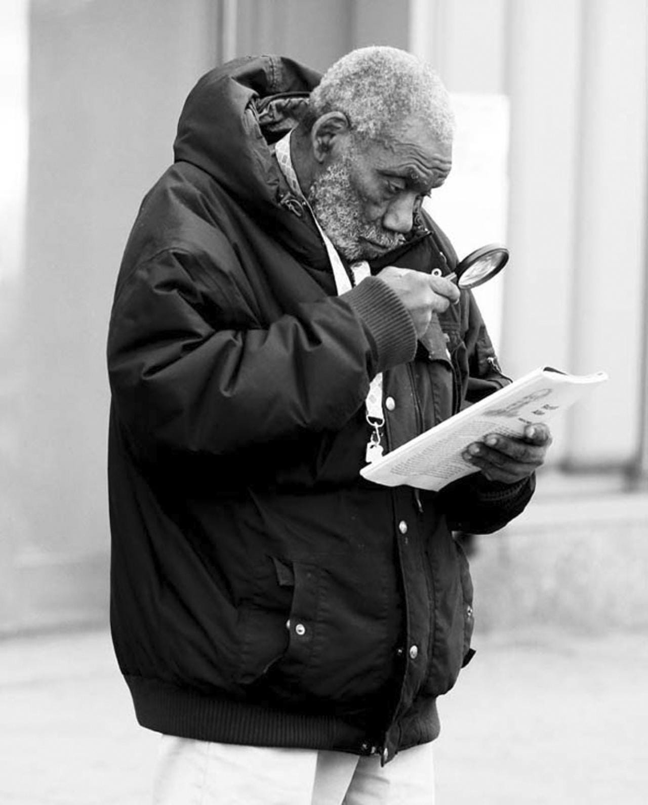 A man reads about the preacher Richard Allen with the help of a magnifying glass.