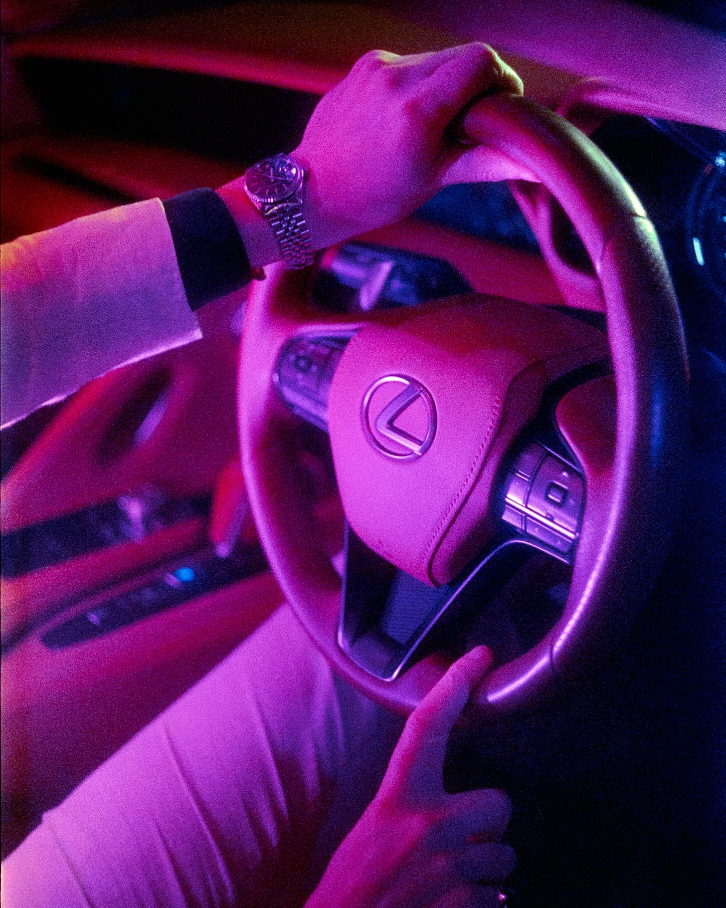 The finalized image, colour corrected and white balanced perfectly. A close up shot of the steering wheel and Clem's hands illuminated by purple light