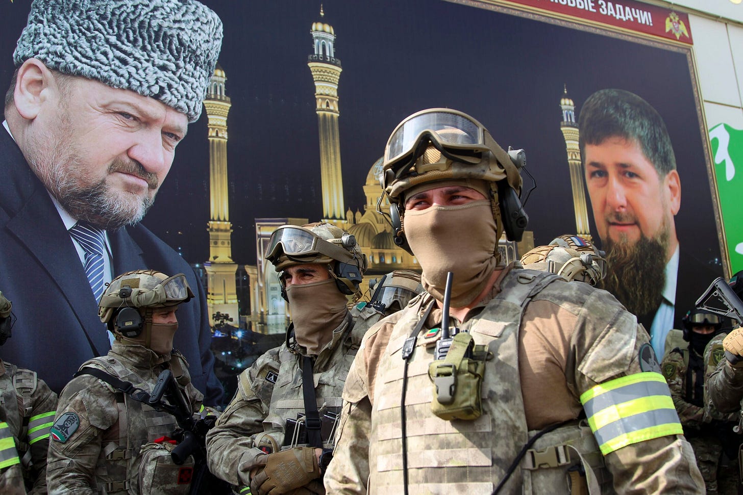 Armed Chechen special forces soldiers attend a celebration dedicated to the 70th anniversary of the birth of the First President of the Chechen Republic, Hero of Russia Akhmad Kadyrov, the Chechen president who was assassinated in a 2004 bomb blast, in Grozny, Russia, Saturday, Aug. 21, 2021. Posters of portraits of Chechnya's regional leader Ramzan Kadyrov and his father Akhmad Kadyrov are seen in the background. (AP Photo/Musa Sadulayev)