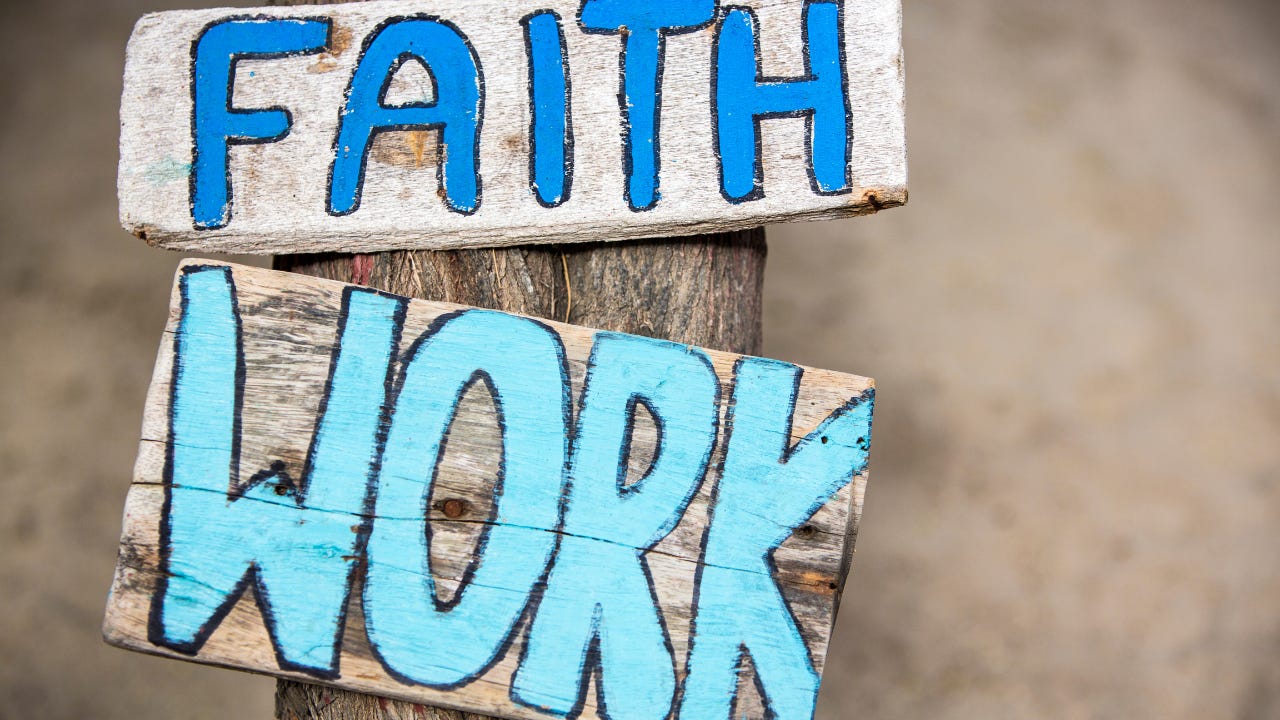 The words, "Faith" and "Work" written on a wooden sign in blue letters.