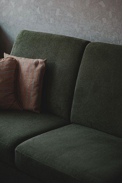 Image of a dark green couch.