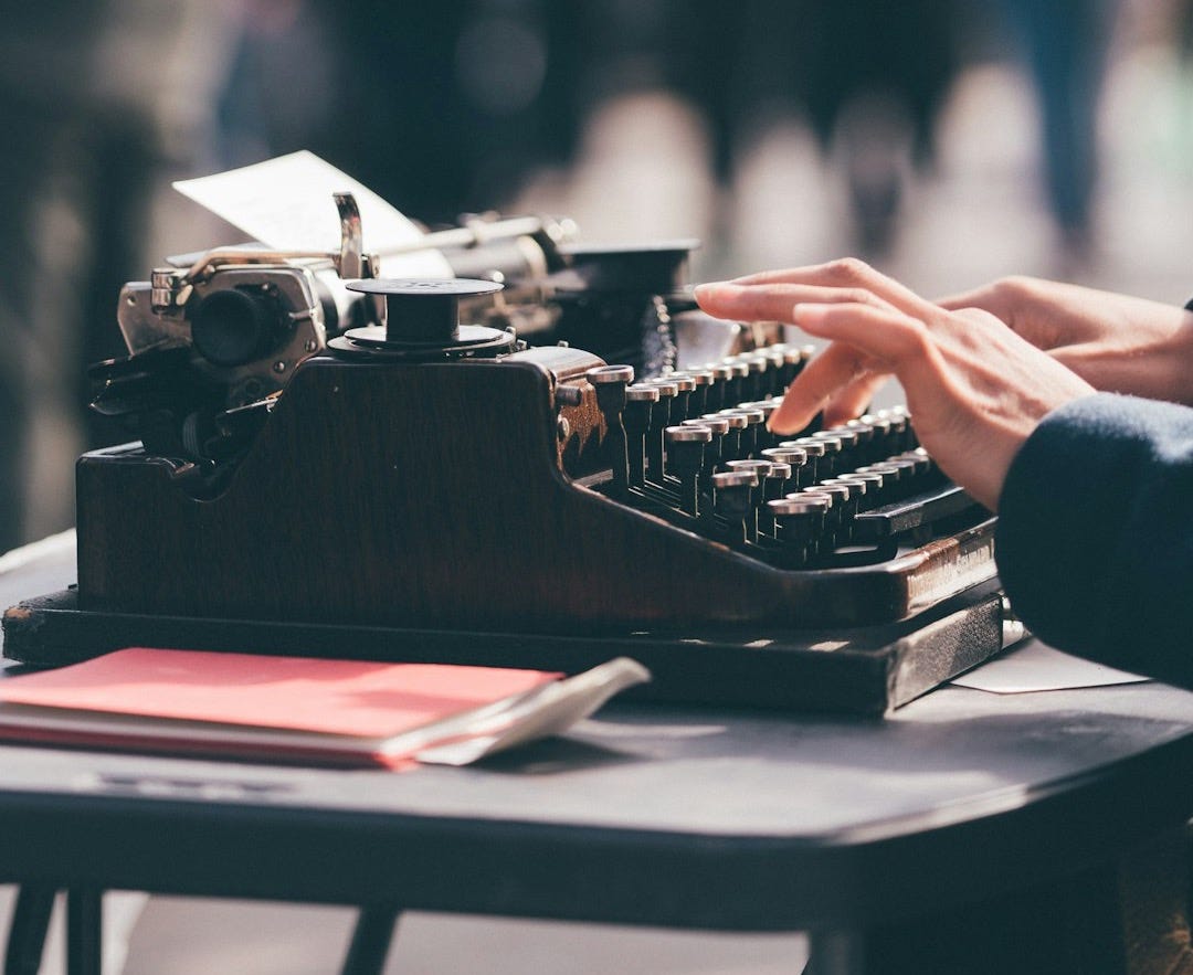 person using black typewriter person using black typewriter