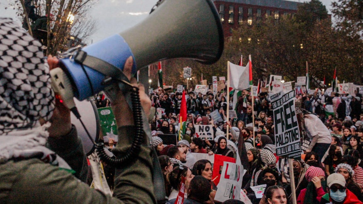 Protester leads chant while others sit in front of the White House during national march for Palestine in Washington, DC on 4 November 2023. [Laura Albast for The New Arab]